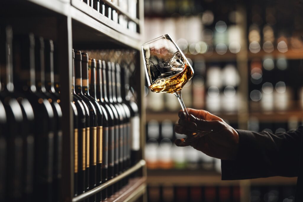 Close-Up of Sommelier Tasting White Wine in Dimly Lit Cellar, focusing on UK Wines.